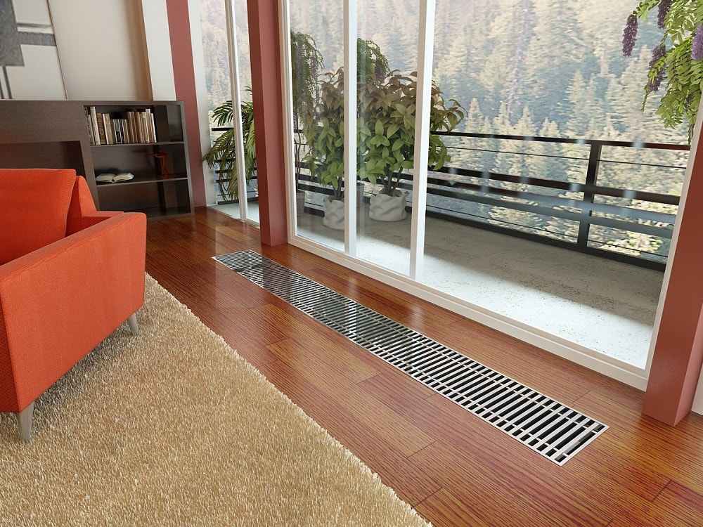 Внутрипольный радиатор отопления с металлическими решетками в жилом доме